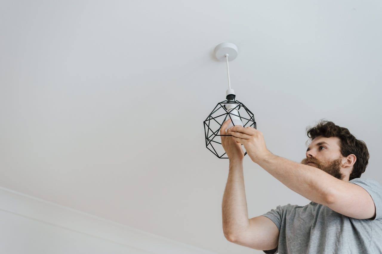 The Art of Drawing Readers In: Your attractive post title goes here From below of male screwing light bulb into new fashionable lamp during renovation work in apartment